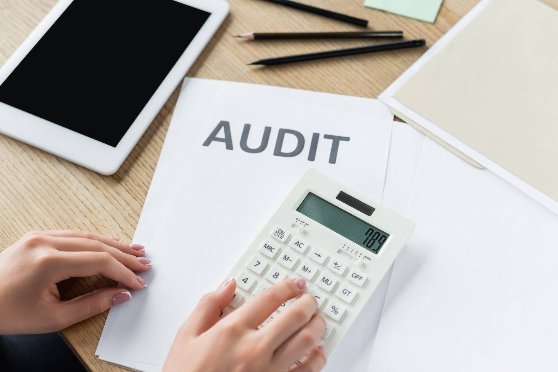 document d'audit sur bureau avec calculatrice et tablette numérique
