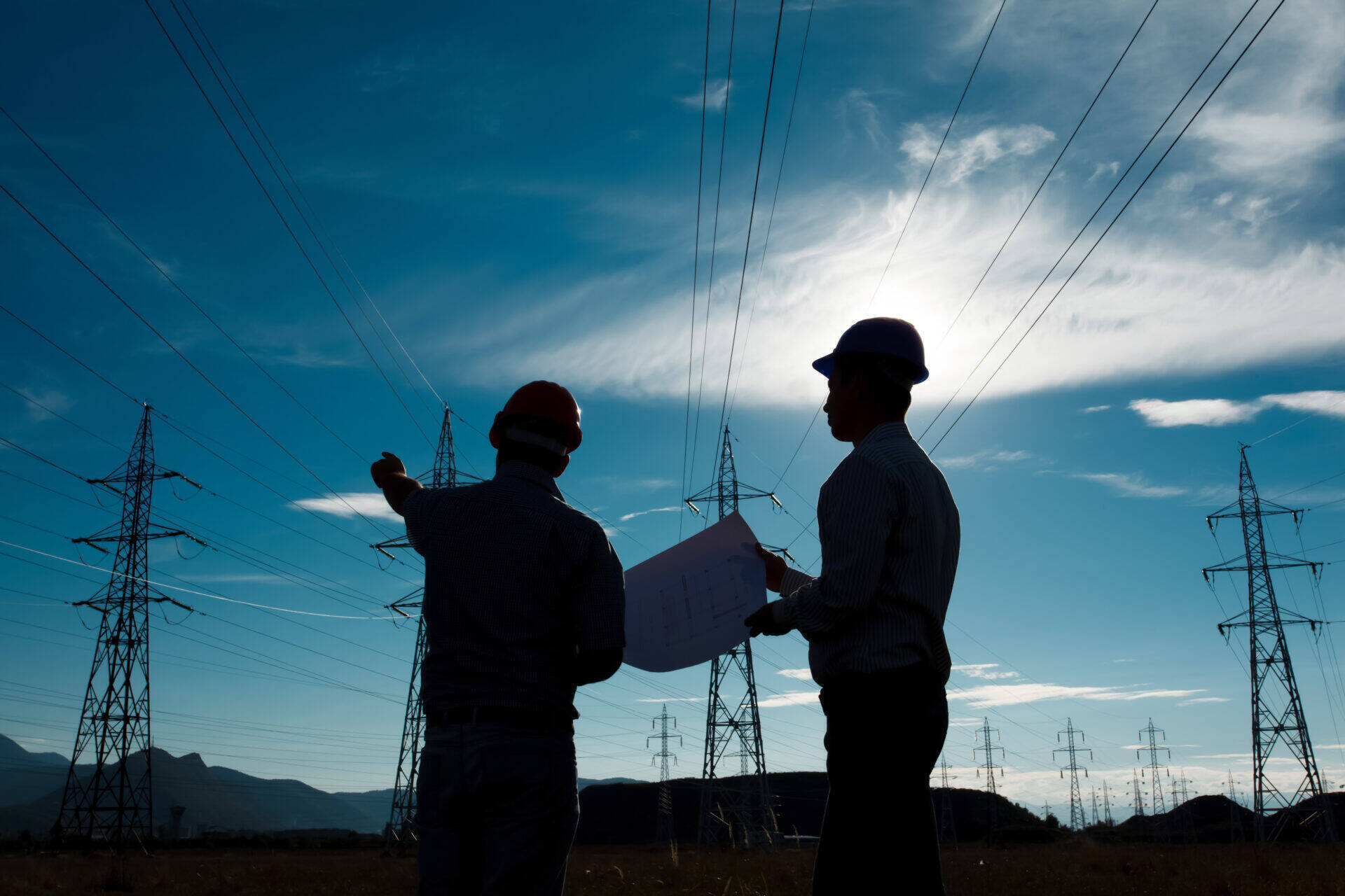 engineers-reviewing-plans-near-power-lines-clear-2026-09-22-15-43-07-utc.jpg