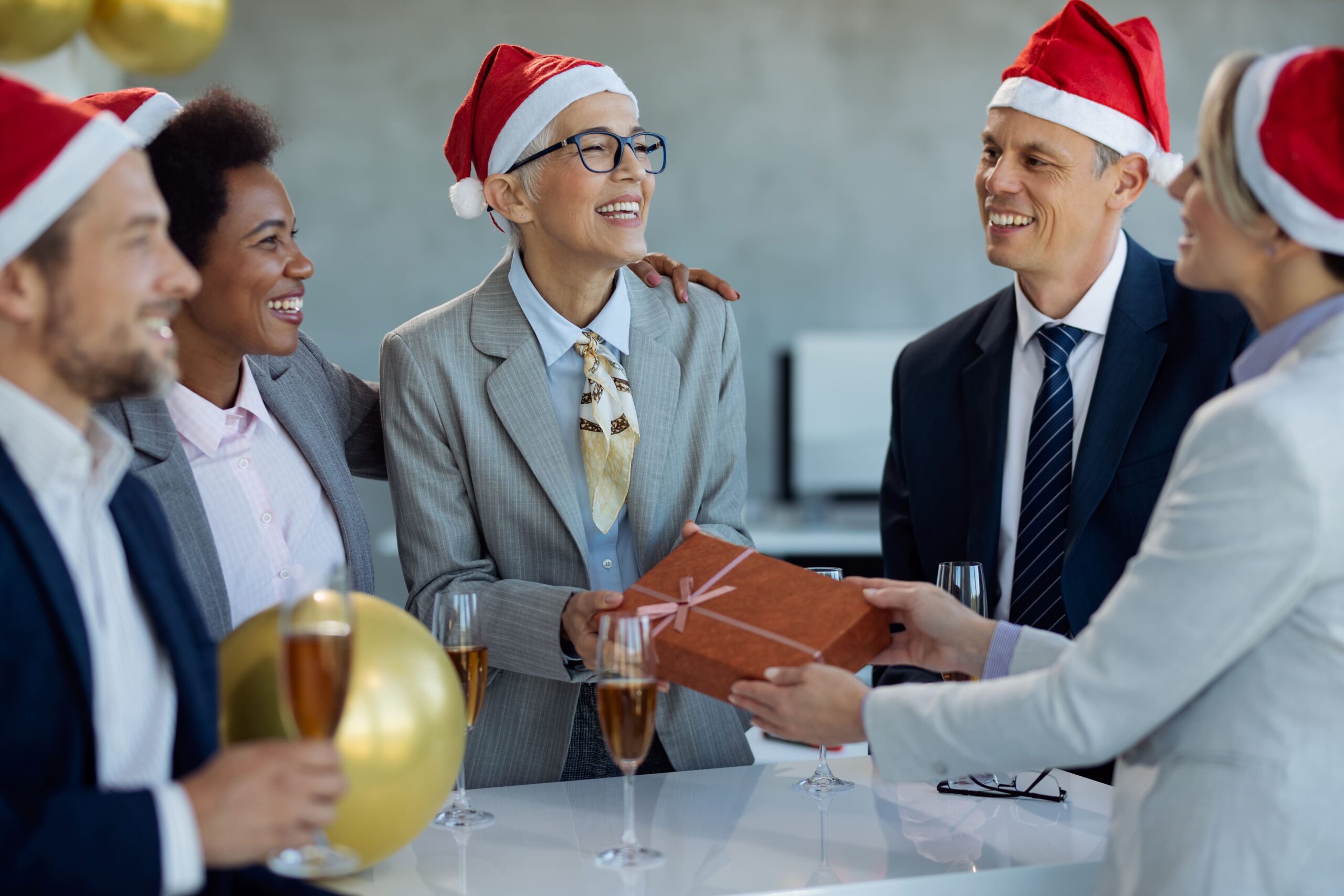 happy-mature-businesswoman-receiving-a-gift-from-h-2024-12-13-18-07-23-utc-1-scaled.jpg